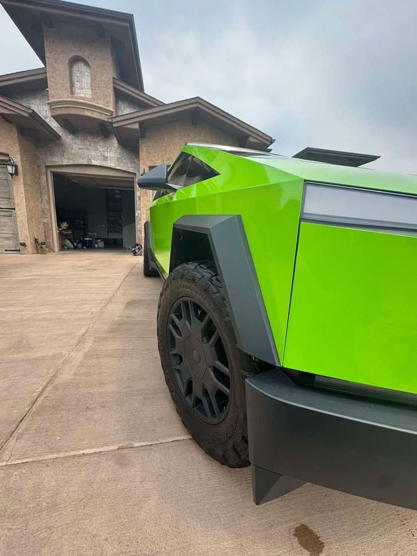 Bright green Tesla Cybertruck parked in front of a house