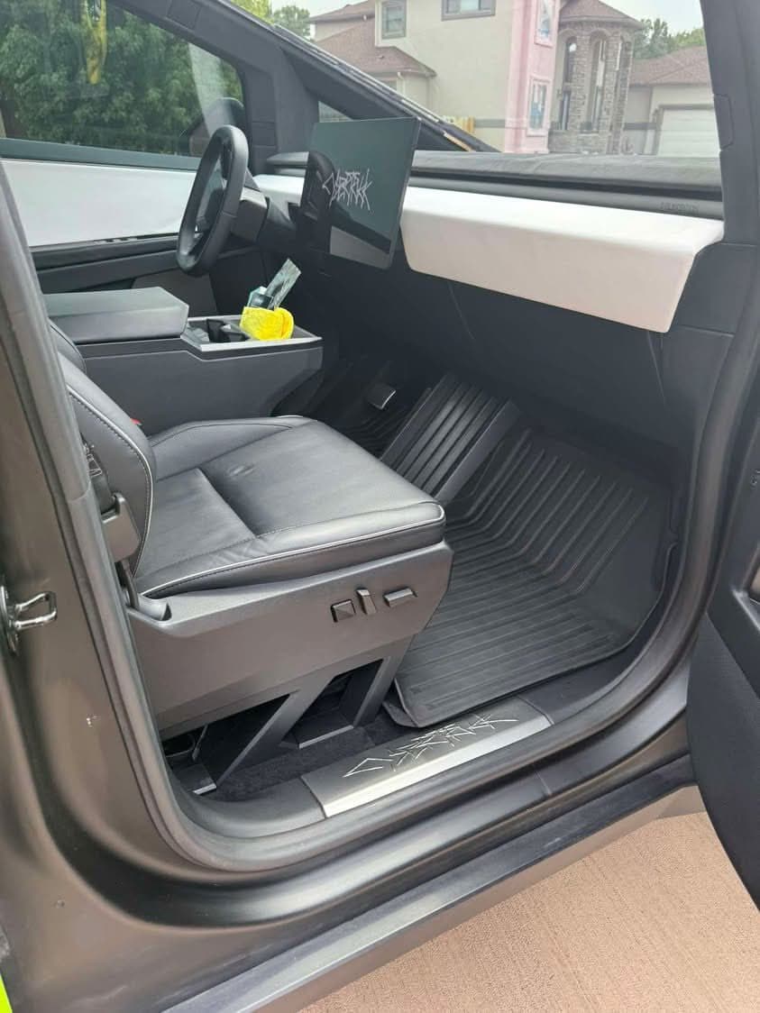 Clean Tesla Cybertruck interior with black seats and floor mats